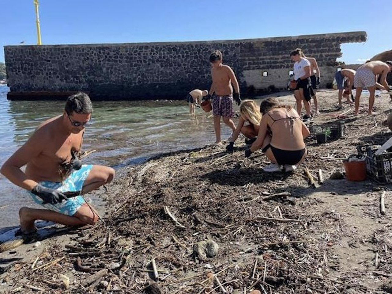 Napoli, dopo le piogge il mare vomita plastica e rifiuti sulla spiaggia della Gaiola e i volontari ripuliscono